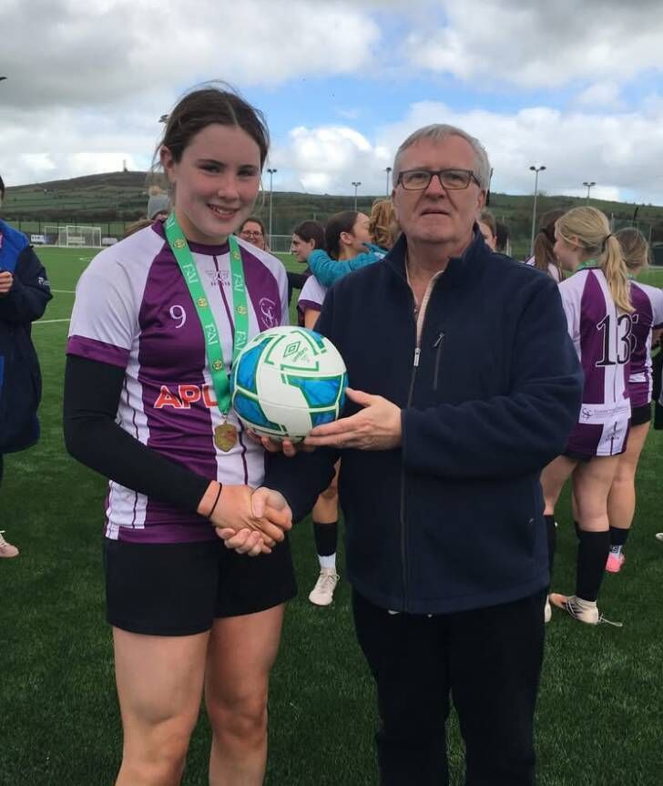 Molly Dennis is presented with the match ball after scoring a hat-trick in the final presented by Aidan Twomey.