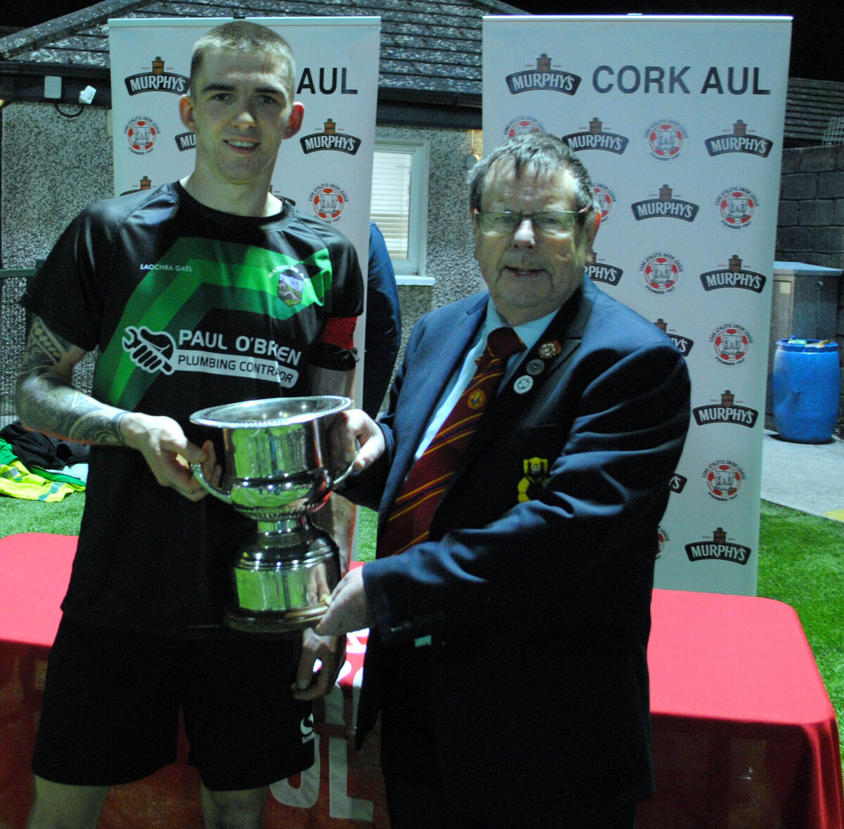 Tom Fitzgerald (Cork AUL) presents the St Michael's Cup to Waterloo's captain Jack Homan. Picture: Barry Peelo.