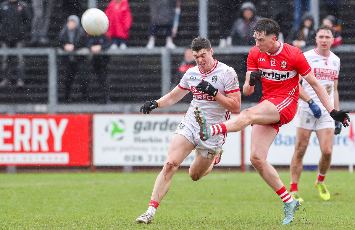 Derry’s Paul Cassidy scores a point as Cork’s Rory Maguire challenges. Picture: Inpho/Lorcan Doherty