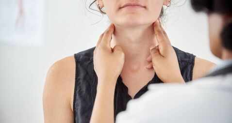 Doctor checking thyroid of a young patient in clinic