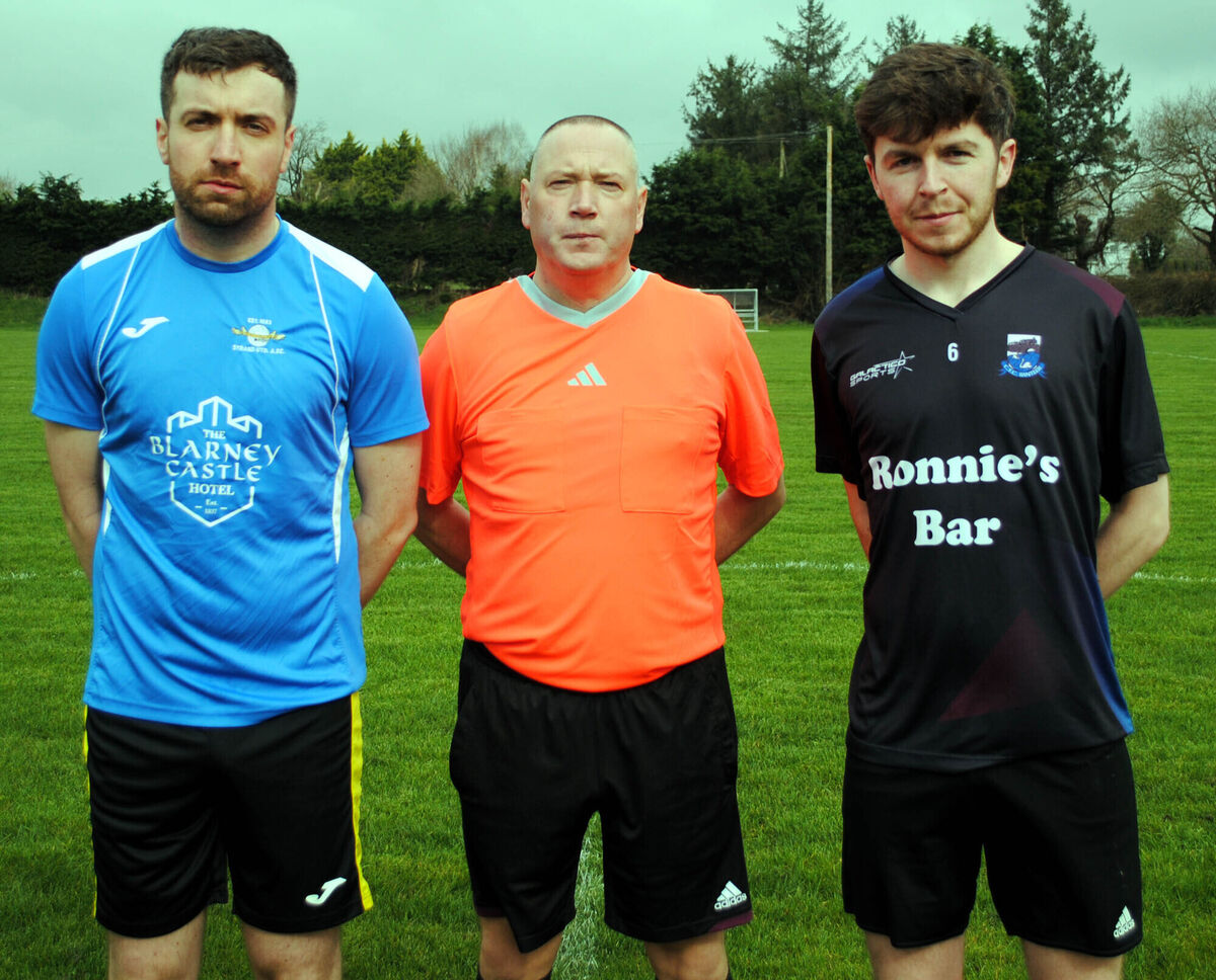 Strand United A captain Adam Scott (left), with CFC Banteer's Alan Coughlan, accompanied by referee alan McDonagh.