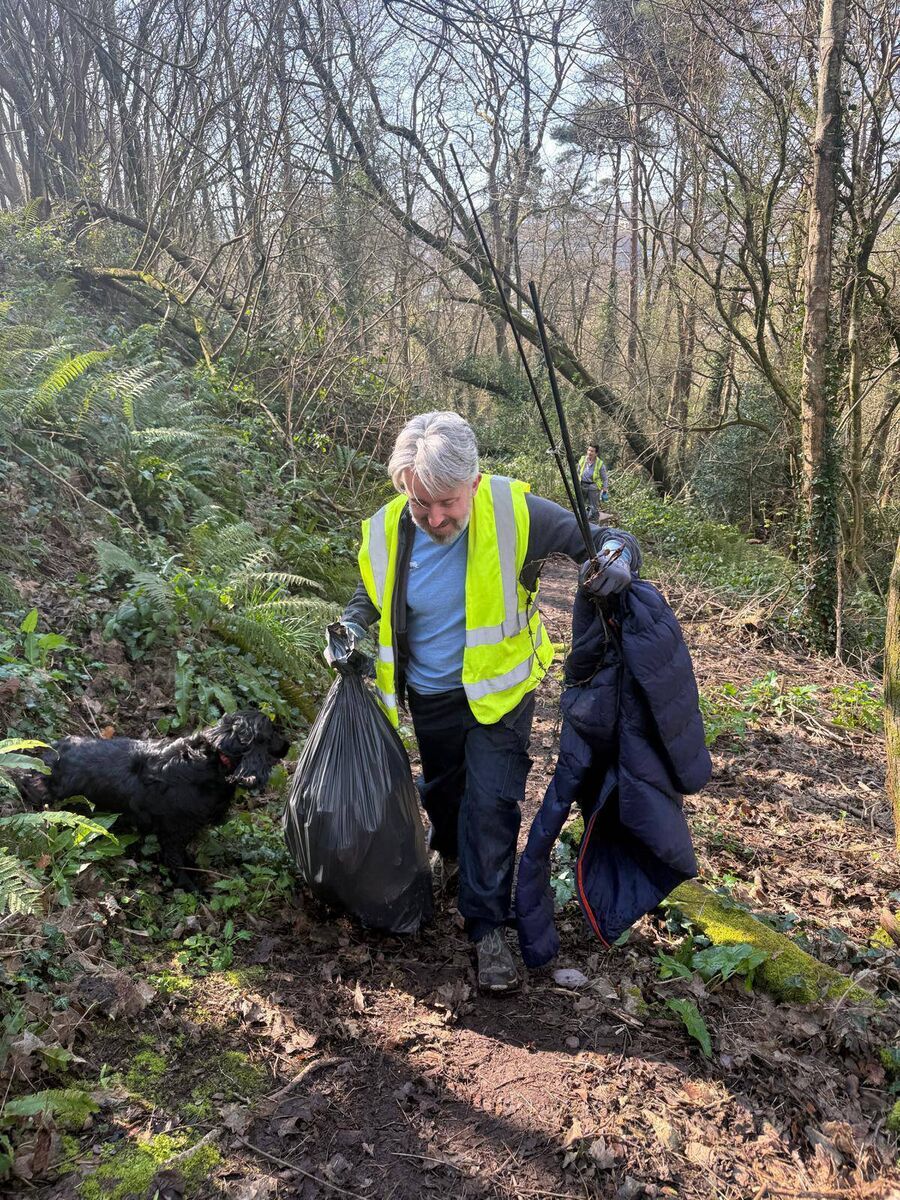 Volunteer Ken Rooney brings a fishing rod, golf jacket, and bag of rubbish from Doman’s Wood.