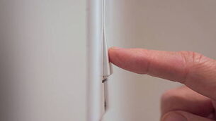 Closeup detail of male finger pushing light switch