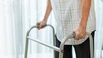 Close up hand of Asian Senior elderly disabled man patient walk slowly with walker at nursing home. Older handicapped male have