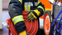 iStock-522313346.jpg Firefighter wearing a rolled hose