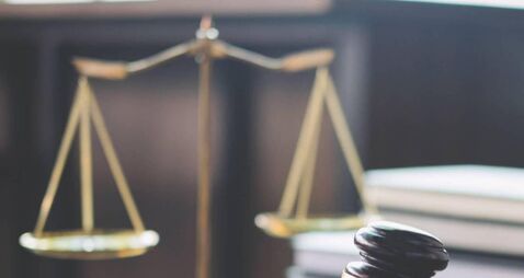 Scales of justice and Gavel on wooden table and Lawyer or Judge working with agreement in Courtroom, Justice and Law concept