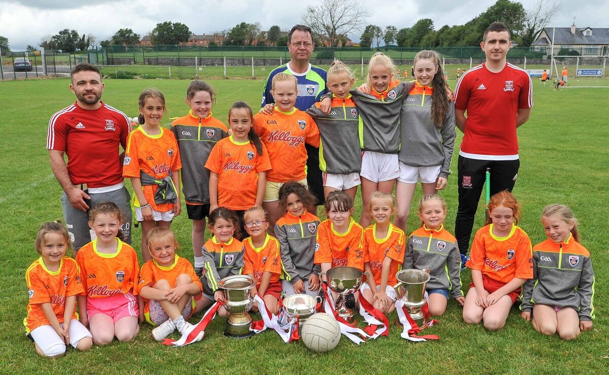 Tony Hegarty, camp co-ordinator, centre, with All-Ireland winning brothers Patrick and Shane Duggan and ladies football club members and the cups won by Mayfield in 2016, at the Mayfield GAA Club Cul Camp.