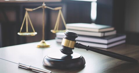 Scales of justice and Gavel on wooden table and Lawyer or Judge working with agreement in Courtroom, Justice and Law concept