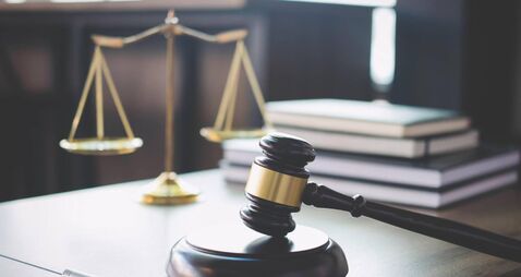 Scales of justice and Gavel on wooden table and Lawyer or Judge working with agreement in Courtroom, Justice and Law concept