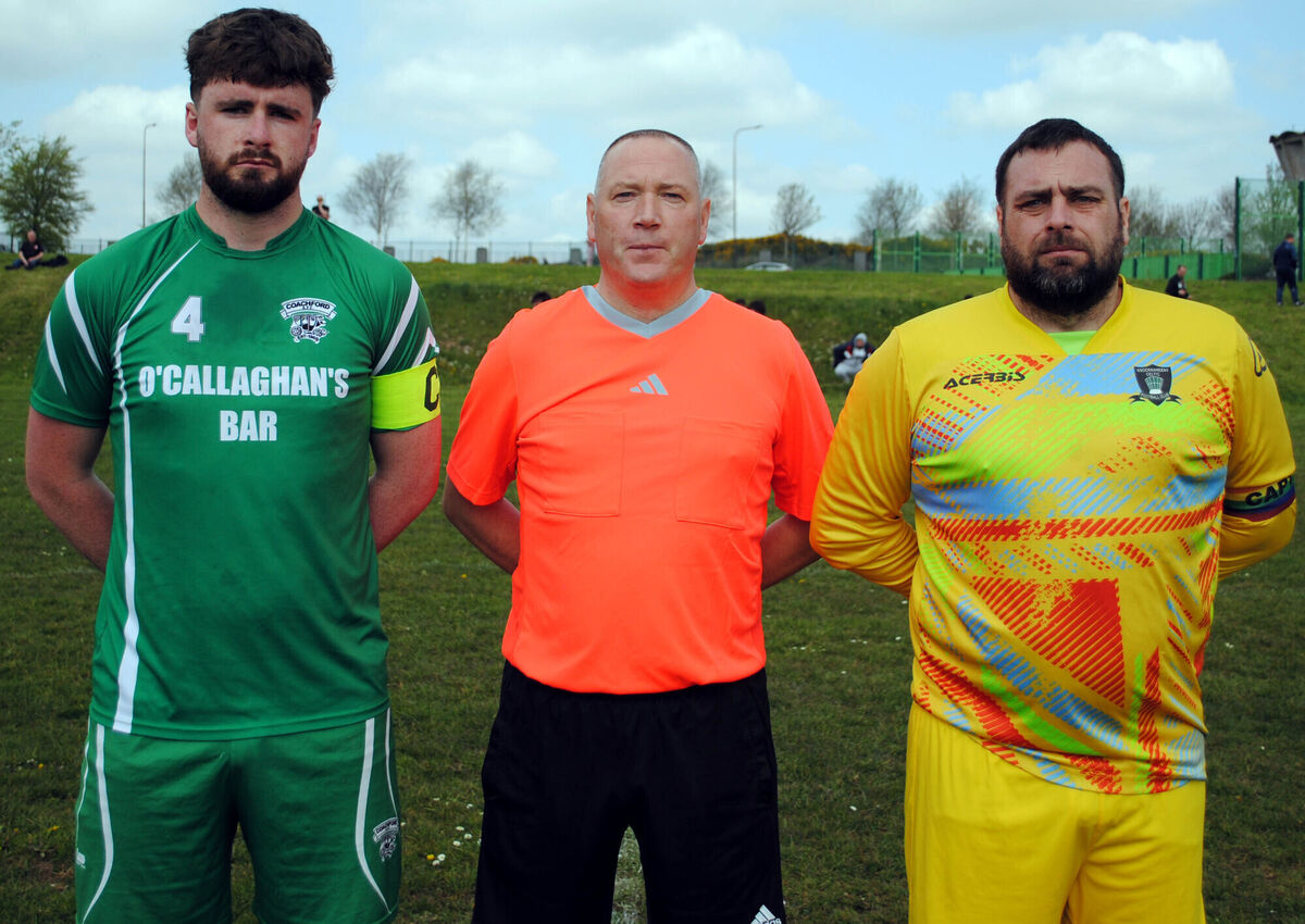 Knocknaheeny Celtic's captain Graham Murphy (right), with Coachford's Mark Murphy, accompanied by referee Alan McDonagh.