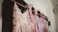 Assortment of women's floral pattern dresses hanging up