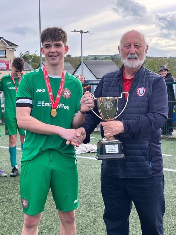 Sean O’Sullivan presents the Daly Industrial Supplies U19 League 1A Cup to Clonakilty captain Timothy Bailey after they beat Carrigaline United at Ballea Park last Sunday.