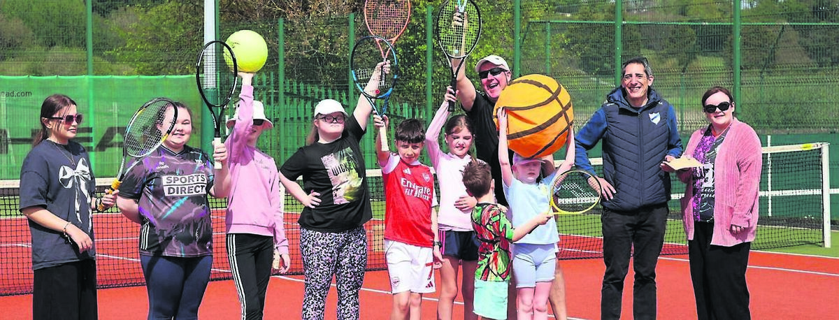 Cheque presentation by Louise Wallace (right), courtesy of ESB, to Marc Khalifa, president of Douglas Laww Tennis Club, during the visually impaired tennis programme at Douglas Lawn Tennis Club; included are members of the group, some helpers, and coach Aidan Cotter (centre).
