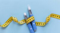 Two injectors dosing pens for subcutaneous injection of antidiabetic medication or anti-obesity medication hovering over a blue