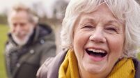 Portrait Of Loving Senior Couple Enjoying Autumn Or Winter Walk Through Park Together