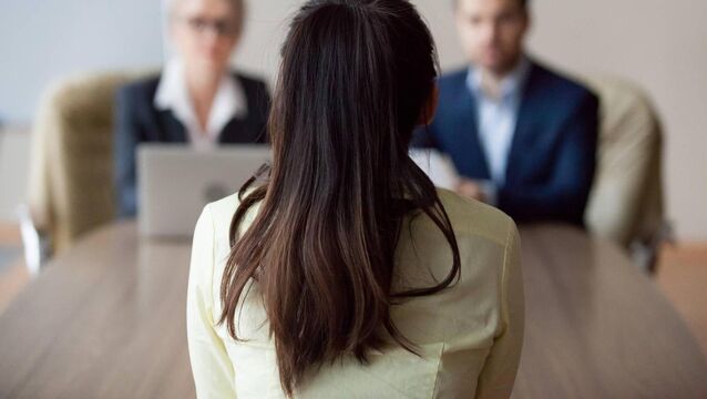 <p>Businesswoman and businessman HR manager interviewing woman. Candidate female sitting her back to camera, focus on her, close up rear view, interviewers on background. Human resources, hiring concept</p>