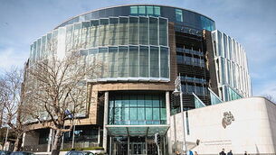 person walking in front of The Criminal Courts of Justice in Dublin, Ireland