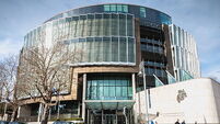 person walking in front of The Criminal Courts of Justice in Dublin, Ireland