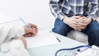 A male patient consults with a doctor about prostate cancer or some other disease.