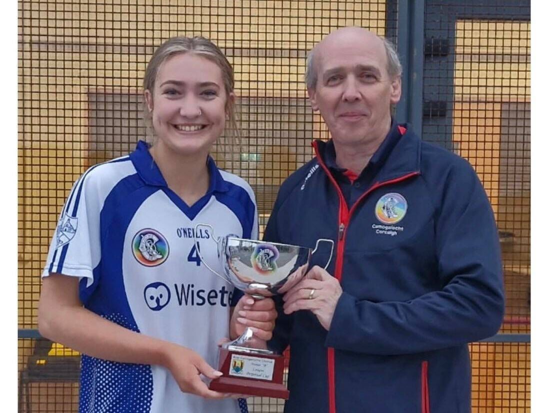 Padraig Treacy presents the Cork Minor B Camogie League trophy to Milford captain Clodagh Geary. 