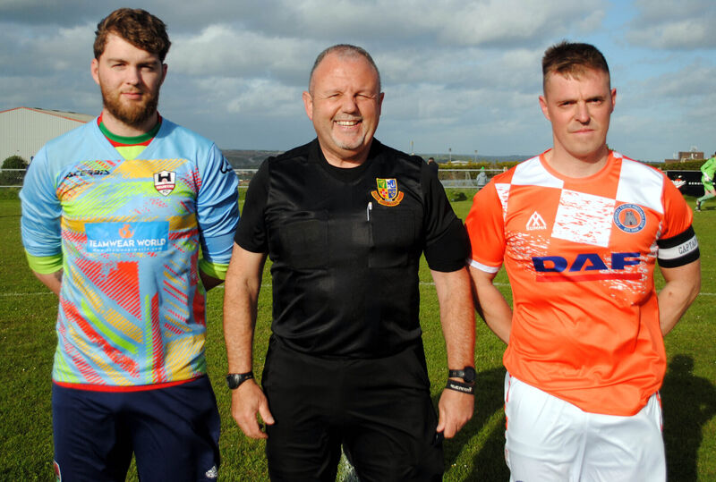 Mallow Town captain Artur Osinski (left) with Cathedral Celtic's Jonathon O'Sullivan, accompanied by referee Paul O'Sullivan. Picture: Barry Peelo.