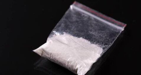 Cocaine in plastic packet on black background
