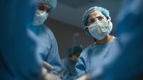 Hispanic medical professional doctor nurse looking serious towards colleagues during surgery operation procedure in hospital