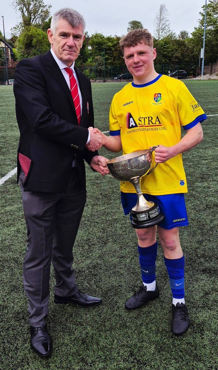 Eddie McEvoy from the Cork Youth League presenting the U18 Premier League Cup to Carrigaline United captain Josh O’Callaghan after they beat Leeside United at Ballea Park.