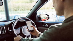 Midsection of man using mobile phone in car