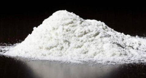 A small pile of white powder on a dark surface