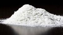 A small pile of white powder on a dark surface