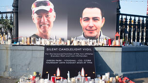 <p>Candles at the foot of photographs of Ivan Chittenden, left, and Brendan Wall at a vigil which was held in their memory in Youghal. Picture: Howard Crowdy</p>