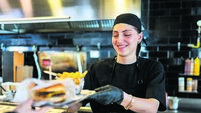 Young woman's first day working at a burger restaurant