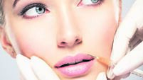 iStock-1047700268.jpg young woman gets botox injection in her lips