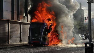 Bus set alight by masked protesters as violence flares following stabbing attack Bus set alight by masked protesters as violence flares following stabbing attack