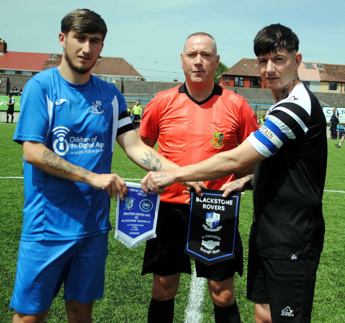 Blackstone Rovers' captain Sean Daly (left) exchanges pennants with Grattan United B's Damien McSweeney, watched by referee Alan McDonagh. Blackstone Rovers' captain Sean Daly (left) exchanges pennants with Grattan United B's Damien McSweeney, watched by referee Alan McDonagh.