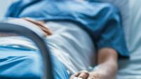 In the Hospital Sick Male Patient Sleeps on the Bed. Heart Rate Monitor Equipment is on His Finger.