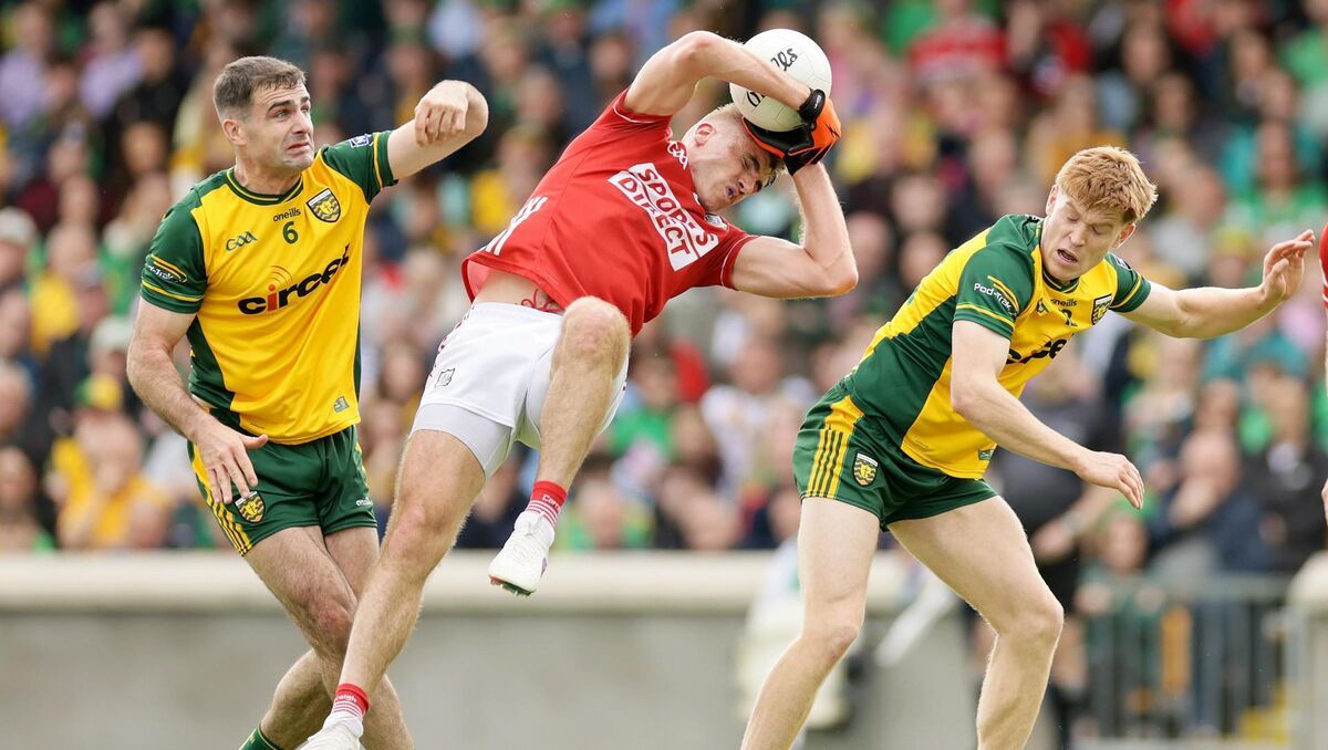 Cork's Ian Maguire wins the ball against Caolan McGonagle and Ciarán Moore of Donegal. Picture: Laszlo Geczo/INPHO