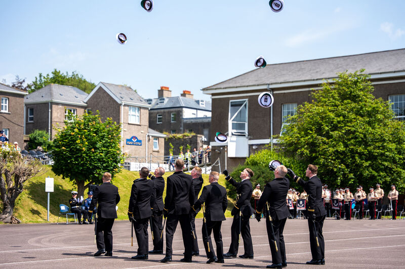 Naval graduates throw their hats in the air at the naval graduation ceremony. 