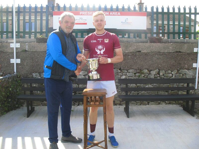Seandún chairman Mick Buckley presenting the trophy to Bishopstown captain David Breen at Ballinlough.