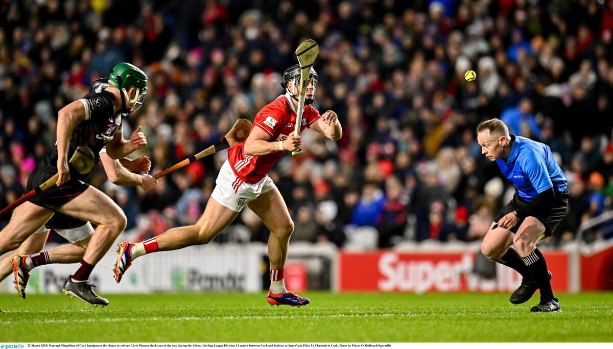 Darragh Fitzgibbon of Cork handpasses the sliotar as referee Chris Mooney ducks out of the way during the 2025 win over Galway at SuperValu Páirc Uí Chaoimh. Picture: Piaras Ó Mídheach/Sportsfile