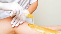 Wax legs iStock-1165541046.jpg Cosmetologist beautician waxing female legs in the spa center beauty salon