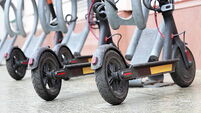 Electric scooters parked on a city street. Self-service transport rental system, e-scooters during a rain
