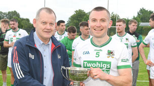 <p> Francis Kenneally, Cork GAA, presents the cup to Kanturk captain Mark Healy after they defeated Bishopstown in the SFL Division 3 final at Glantane. Picture: David Keane.</p>