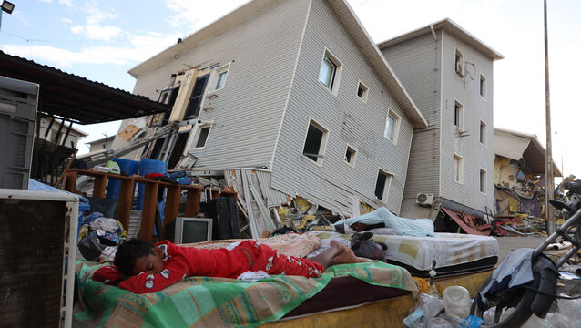 <p>A boy sleeps outside earthquake-damaged homes in Catia La Mar, Venezuela. (Picture: AP Photo/Pedro Mattey)</p>