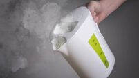 White Boiling Kettle in hand on dark background