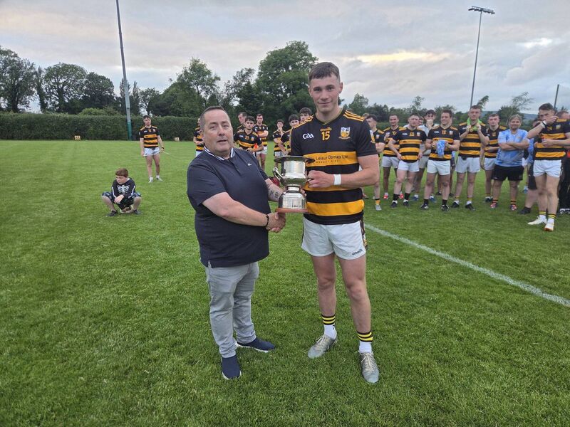 Jim McEvoy of Cork GAA presents the Division 4 trophy to Mark Lenahan of Buttevant.