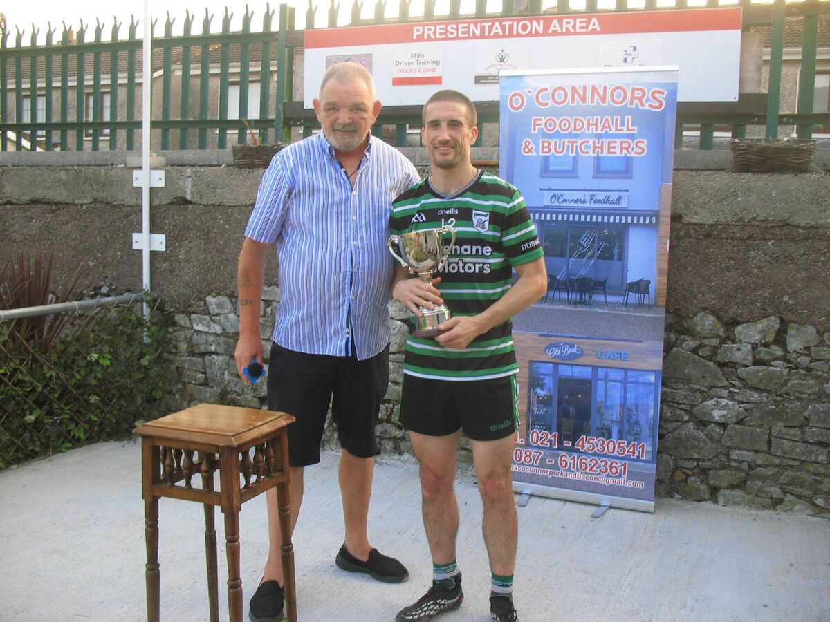 Seandún Chairman Mick Buckley presents the Seandún Cup to Douglas winning captain Kevin Murphy 