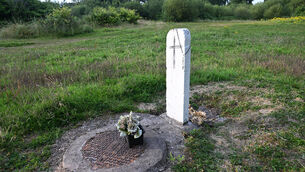 <p> A simple black cross and rosary beads have been added to a manhole marker which has been painted to resemble a headstone on the grounds of the former Bessborough Mother and Baby Home institution. Picture: Larry Cummins</p>