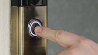 A man presses the button on a "Ring" internet video door-bell from ring.com.